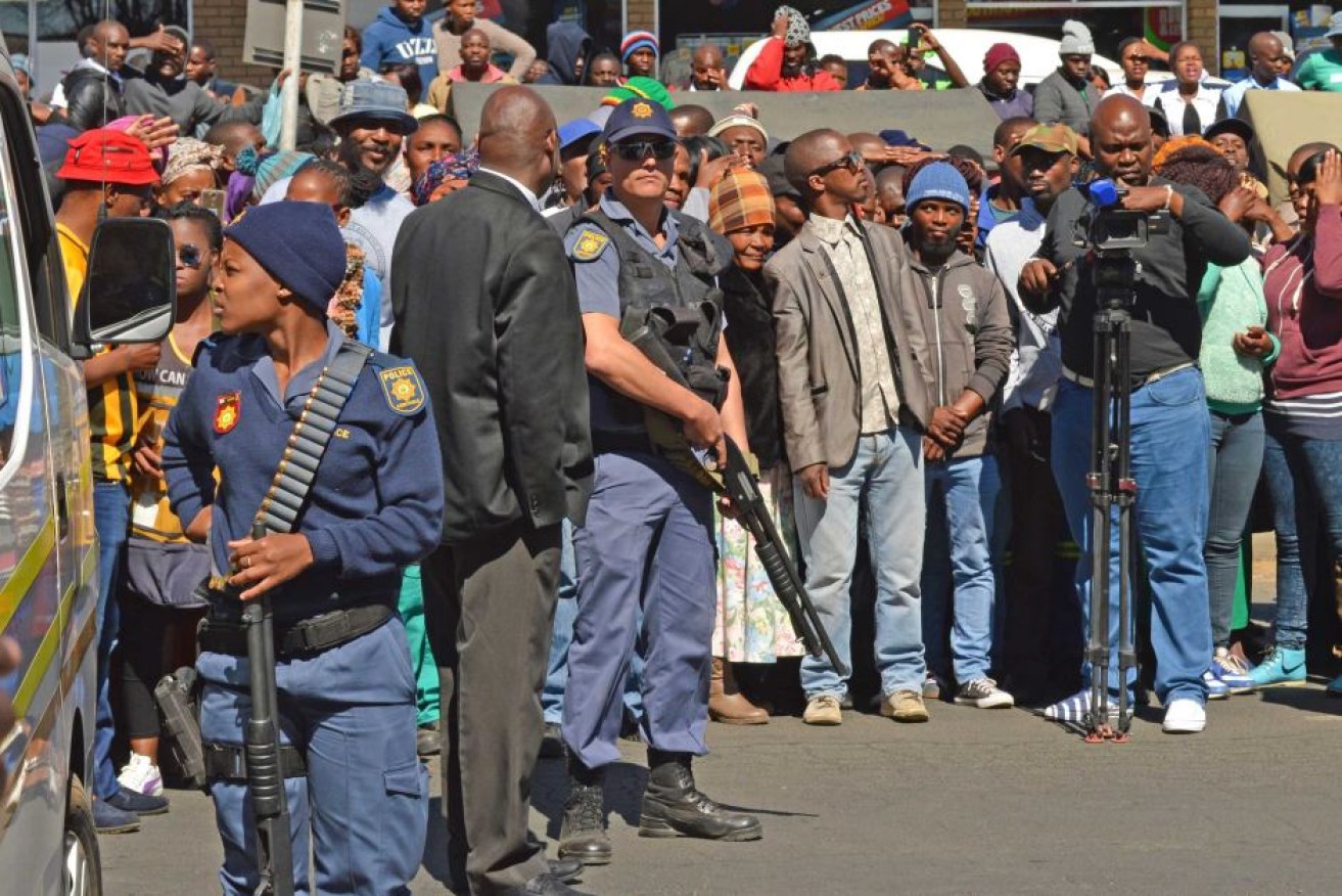 Crowds and armed police gather outside the court amid the appearance of the accused suspects.
