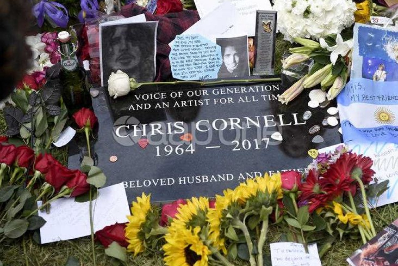 Flowers, guitar picks and handwritten notes on Chris Cornell's headstone. 