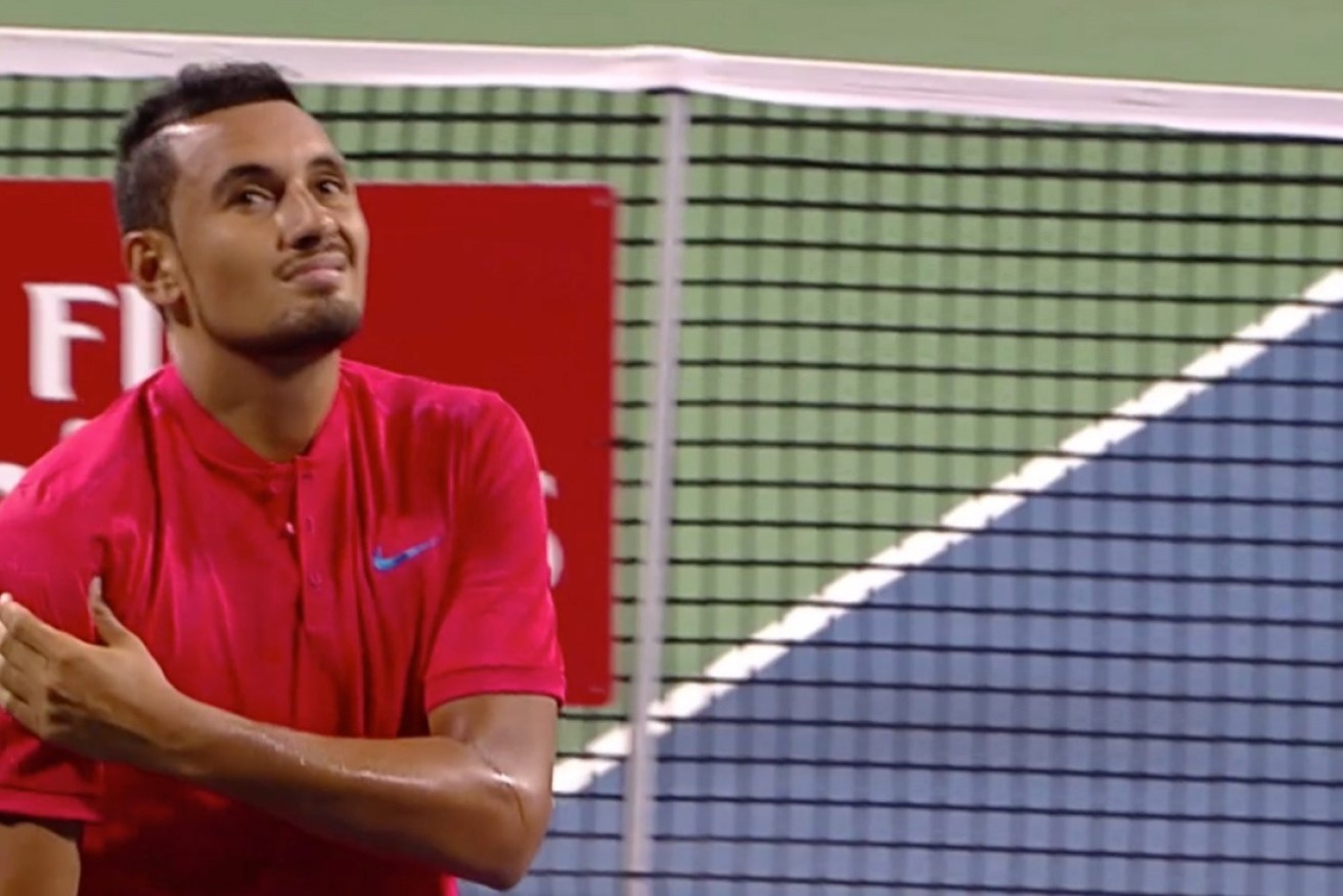Kyrgios grabs at his shoulder during the match.