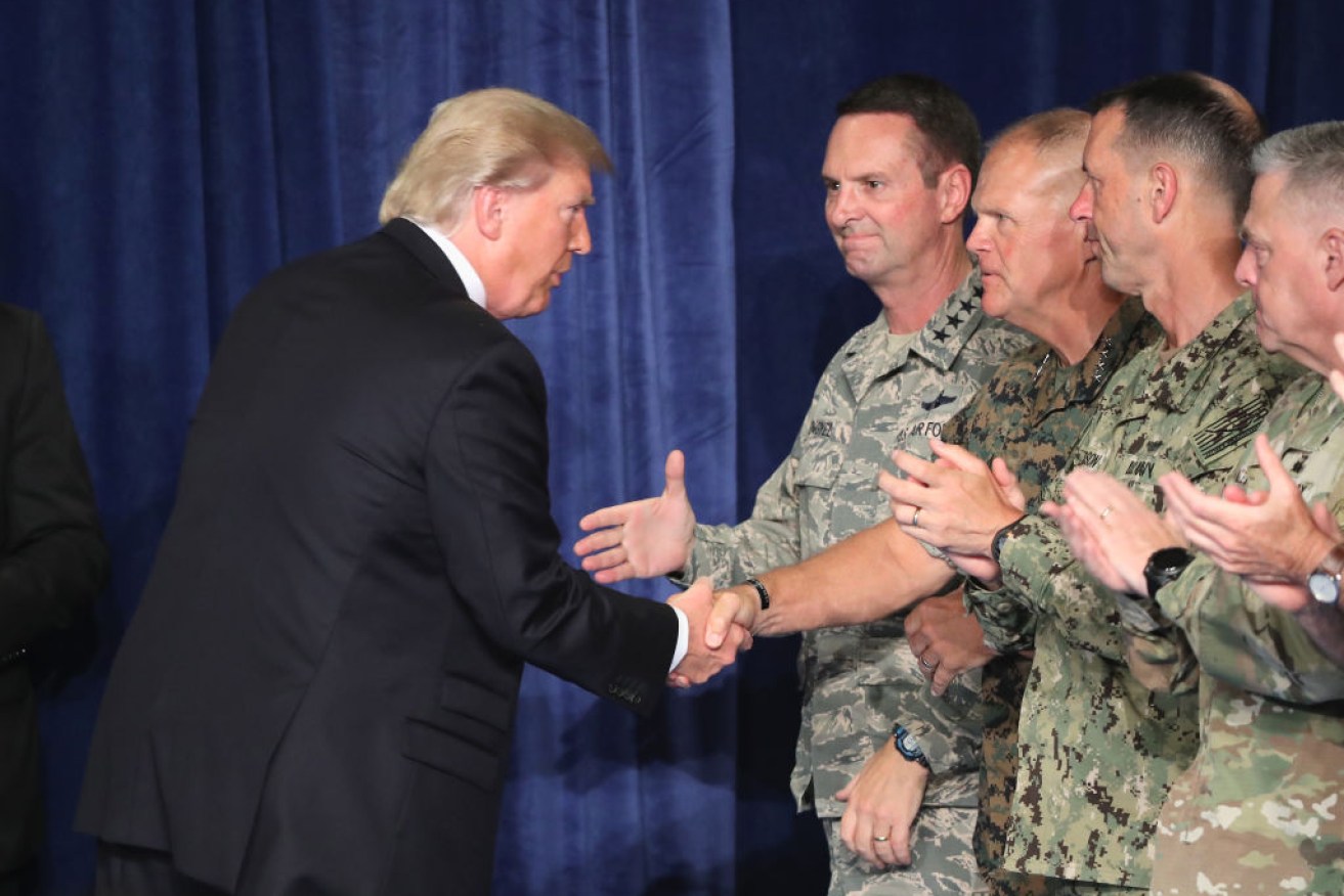 President Donald Trump greets military leaders before his speech on Afghanistan