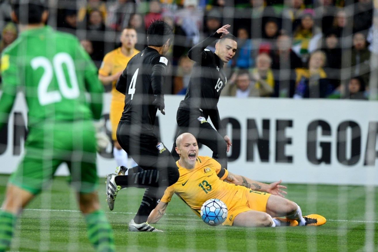 Socceroos Aaron Mooy is brought down in the box during the match against Thailand. 