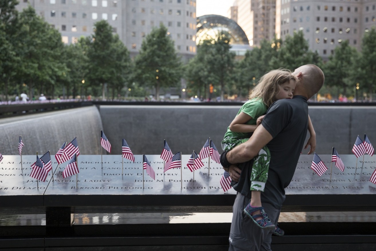 A man and his daughter take time out at the 9/11 memorial pool in New York. 