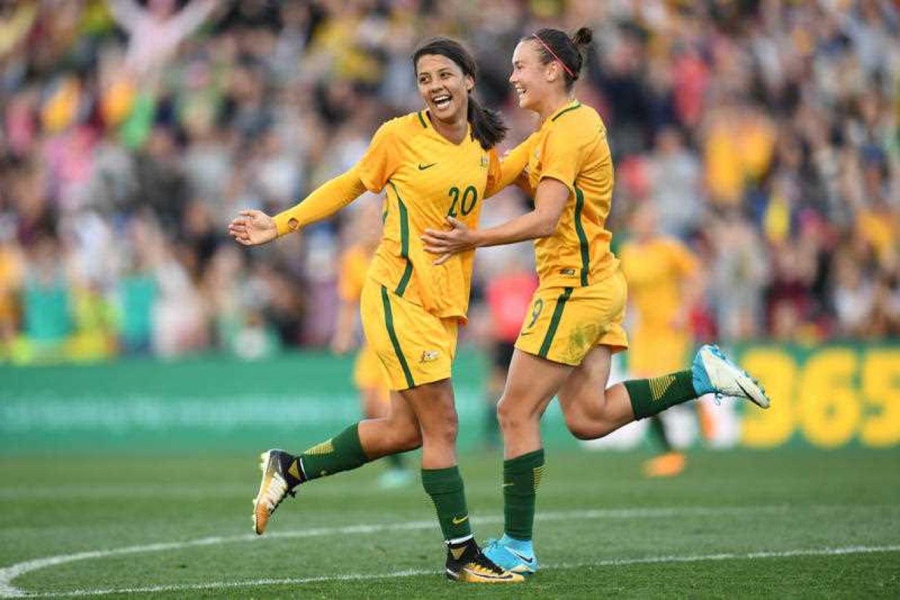 Sam Kerr (left) celebrates her goal with Caitlin Foord, helping the Matildas beat Brazil in Newcastle.