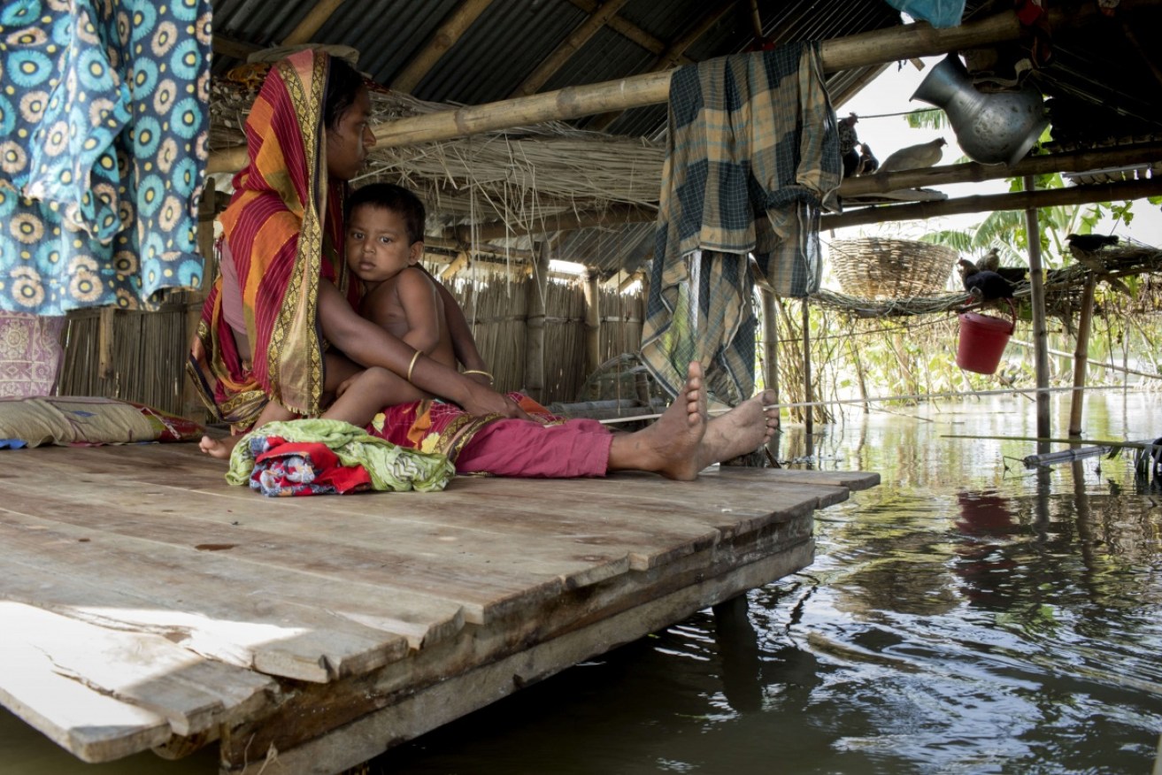 Najma sits with her child on a bed inside their flooded house at Sariakandi, Bogra in Bangladesh. Floods caused by heavy rainfall lashing Bangladesh during the past week have left thousands of people dead. 