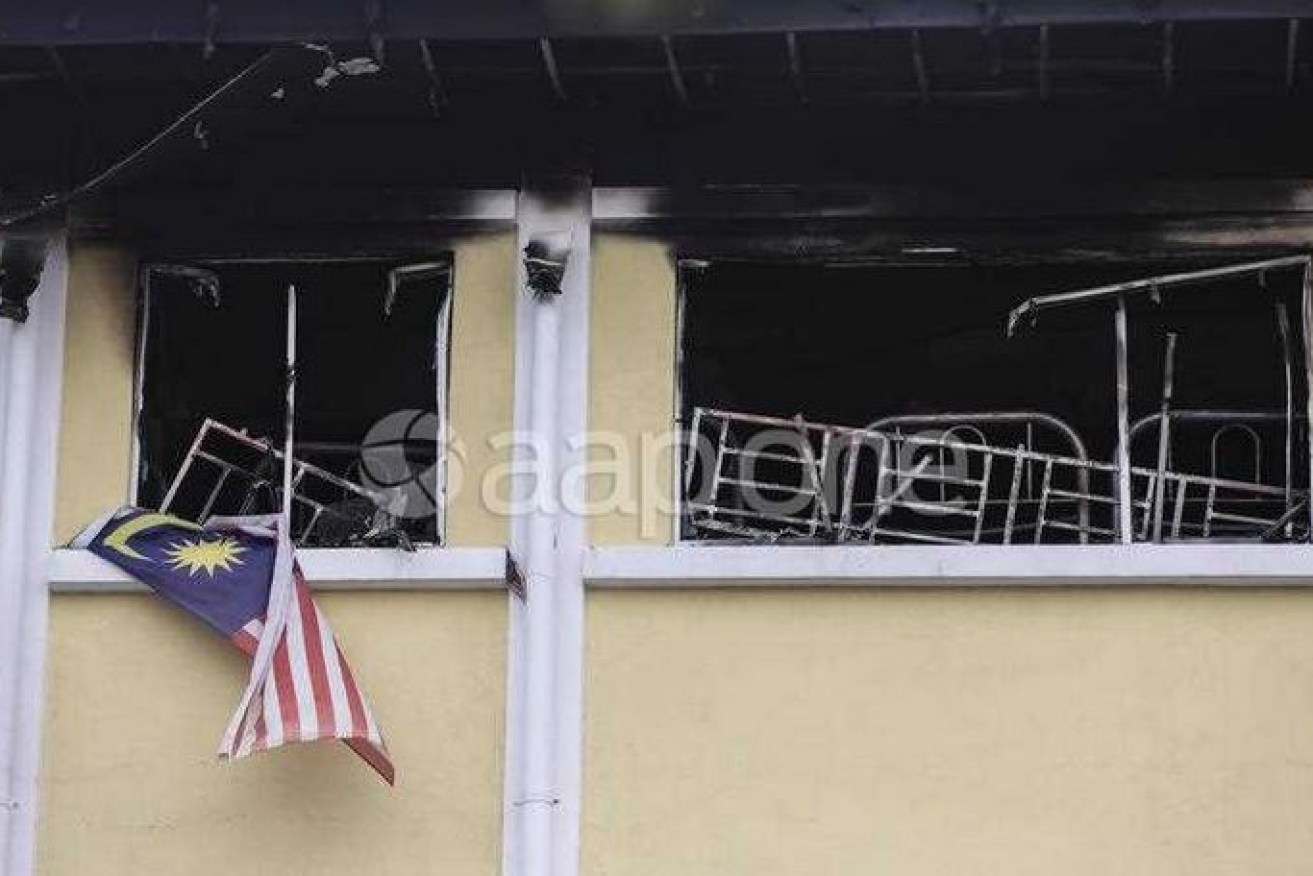 Malaysia's flag and a charred bed mark the spot where 23 students lost their lives.