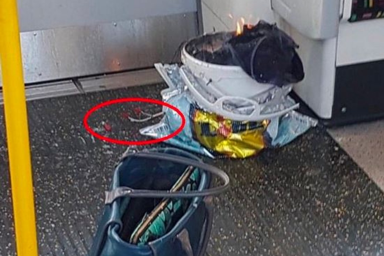 A canvas bag with protruding wires (circled)  smoulders beside an abandoned handbag.