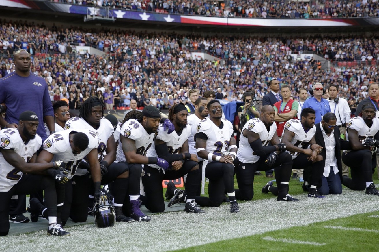Baltimore Ravens players kneel during the US national anthem at their game against the Jacksonville Jaguars at Wembley Stadium, London.