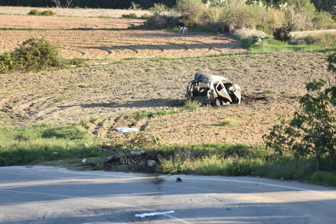 The wreck of Daphne Caruana Galizi's car lies in a field near her home in Malta. 