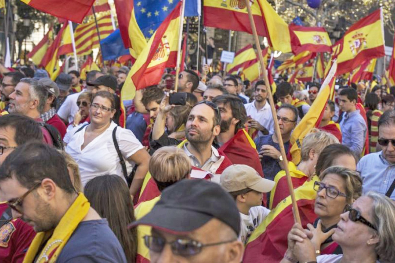 Hundreds of thousands of Spaniards have taken to the streets of Barcelona in a pro-unity march, with a poll showing a lead for the anti-independence party.