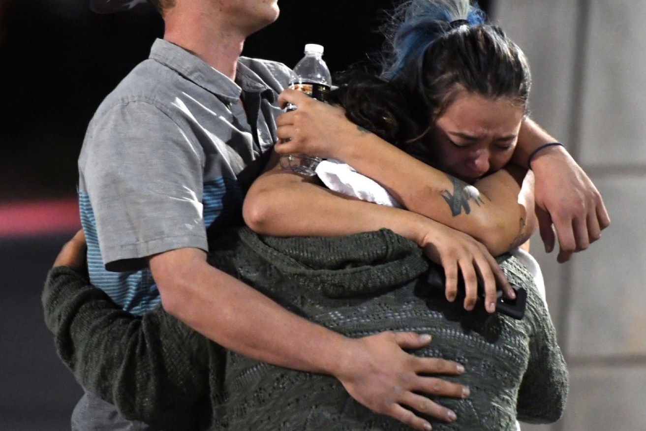 People hug and cry outside the Thomas & Mack Centre after a mass shooting at the Route 91 Harvest country music festival.