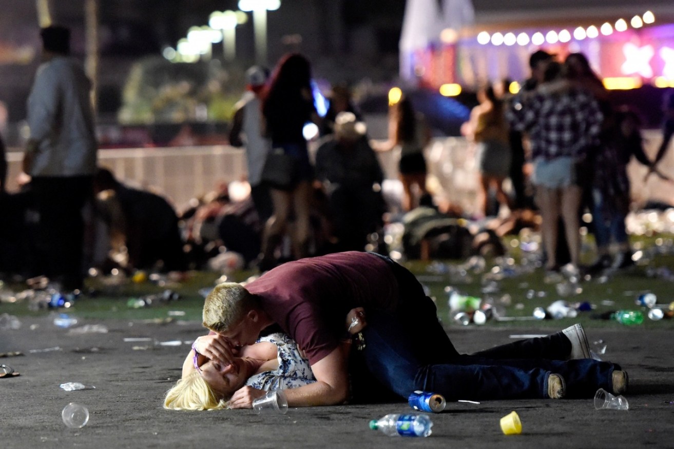 A man desperately comforts a woman in the aftermath of the Las vegas shooting