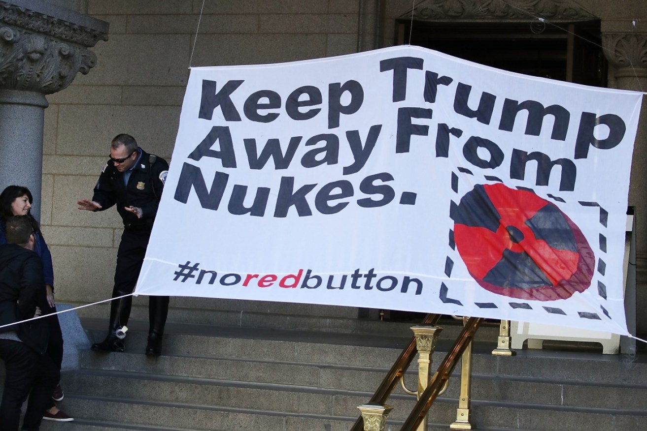 Protesters unfurl an anti-nukes banner outside Donald Trump's Washington hotel