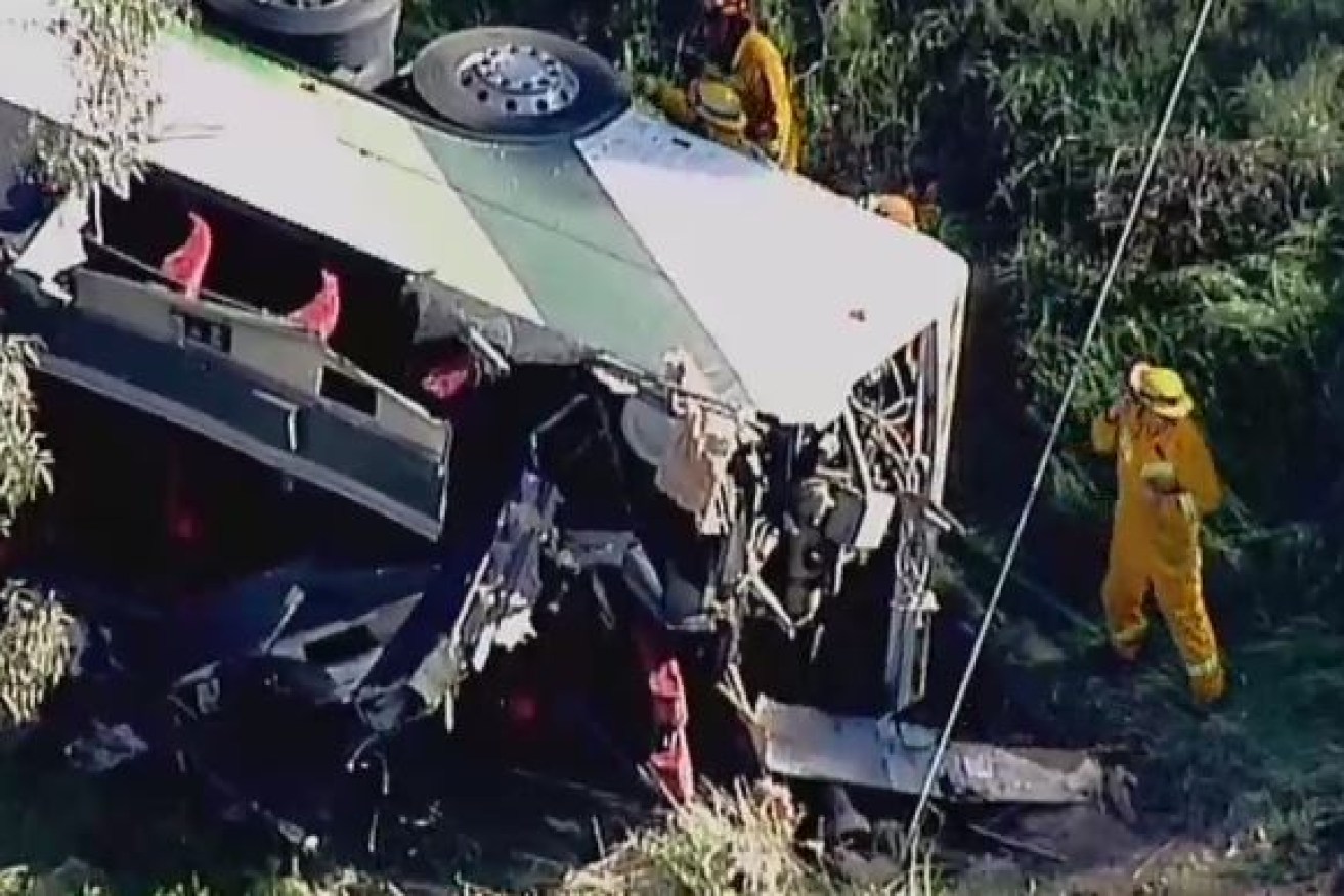 Emergency workers swarm around the wreckage of the bus on Victoria's Sunraysia Highway.