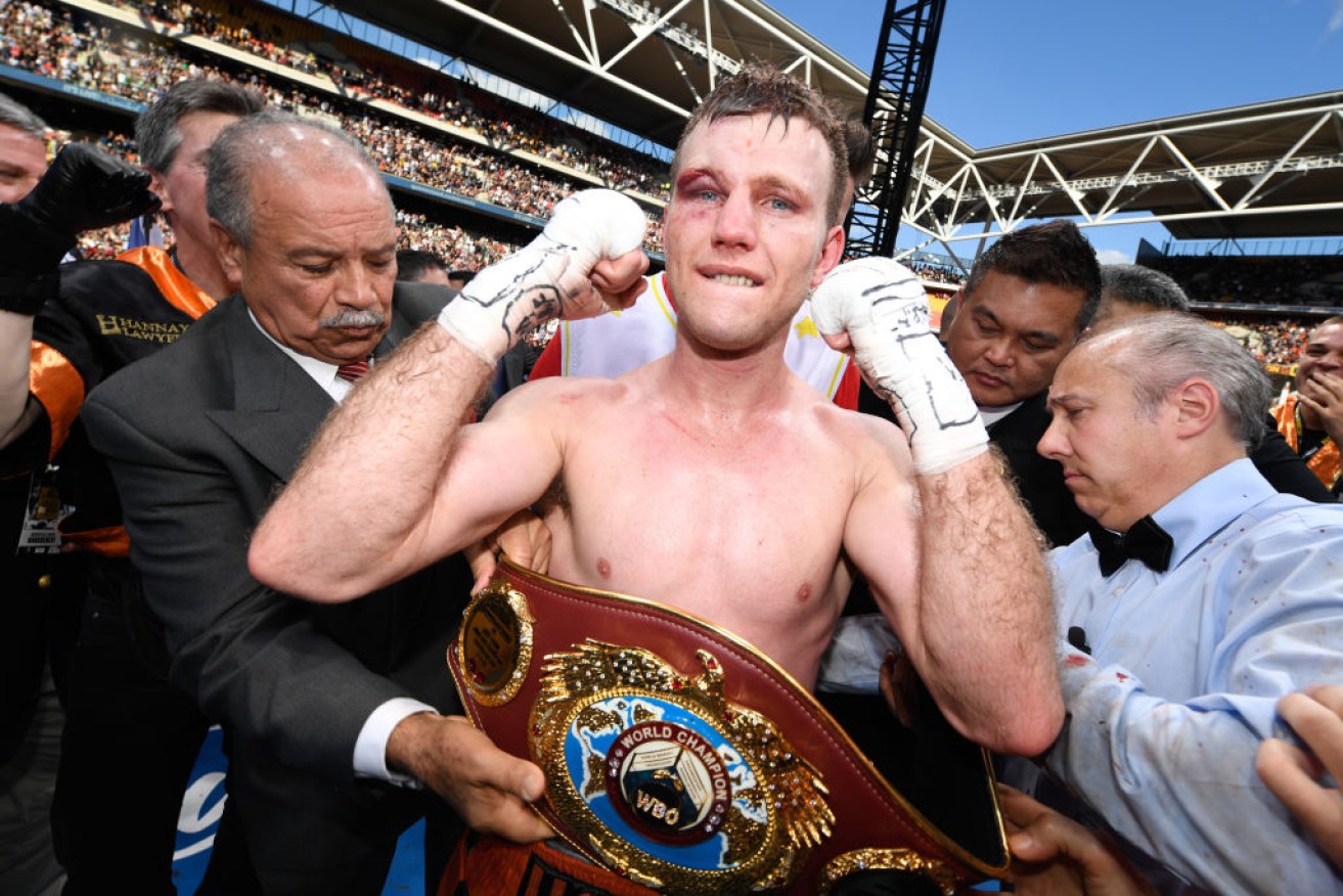 Horn claims his belt after his unanimous victory over Pacquiao at Brisbane's Suncorp Stadium. 