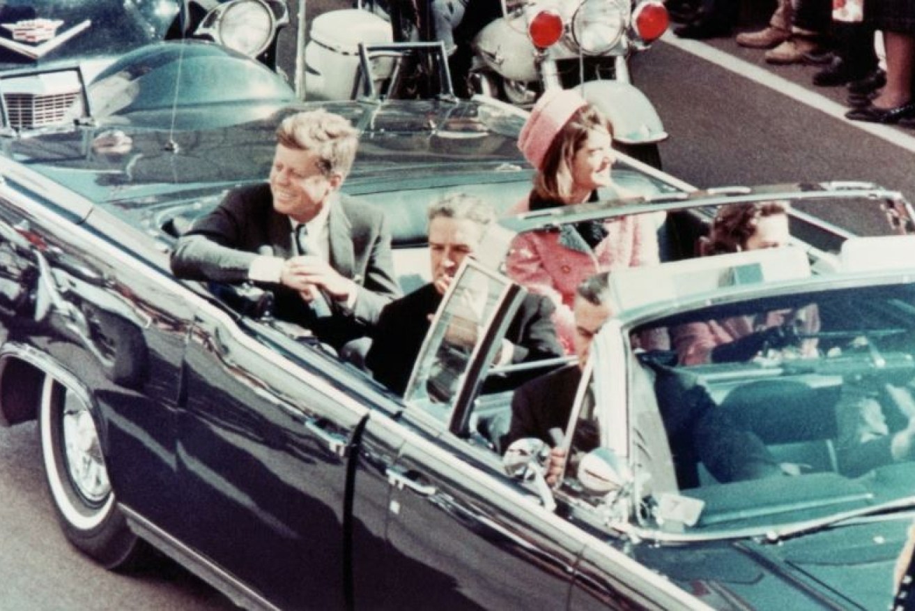 Seconds before the bullets ended his life, John F. Kennedy shares his famous smile with the Dallas crowd.