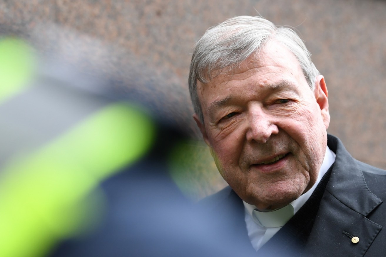 George Pell walks the gauntlet outside the Melbourne Magistrates Court. 