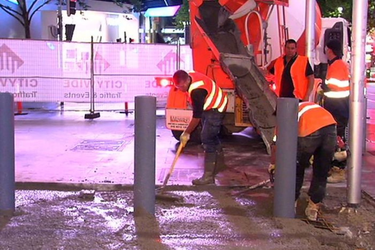 Workers install the new bollards in the Melbourne CBD this week. 