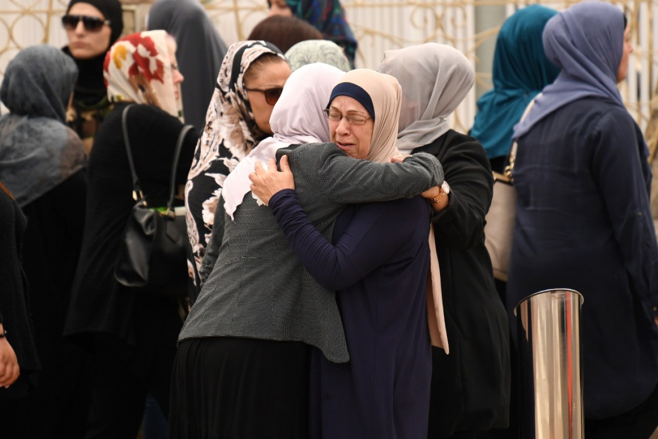 Mourners embrace at the funeral of one of the boys killed in an accident at Banksia Road Primary School.