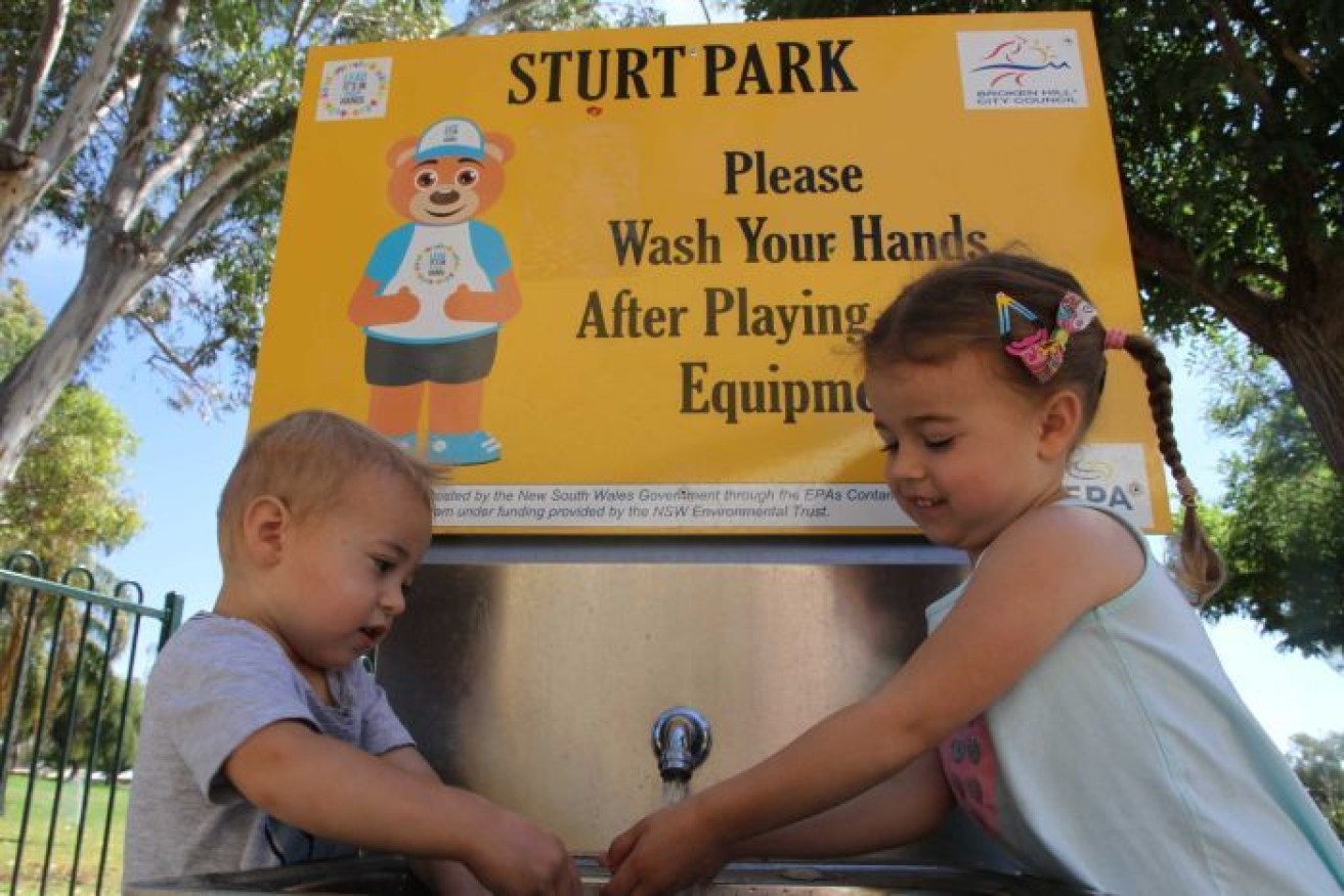 Zac and Issy Toigo wash their hands at a hand washing station in a Broken Hill park to avoid ingesting lead. Photo: ABC
