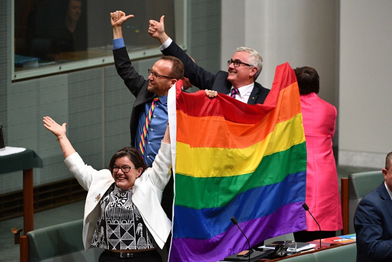 Crossbenchers Cathy McGowan, Adam Bandt and Andrew Wilkie celebrate the passing of the bill.