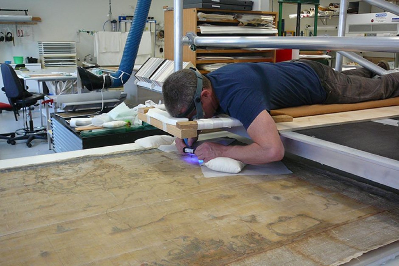 Conservator Peter Mitchelson removing varnish from the surface of the Blaeu map.
