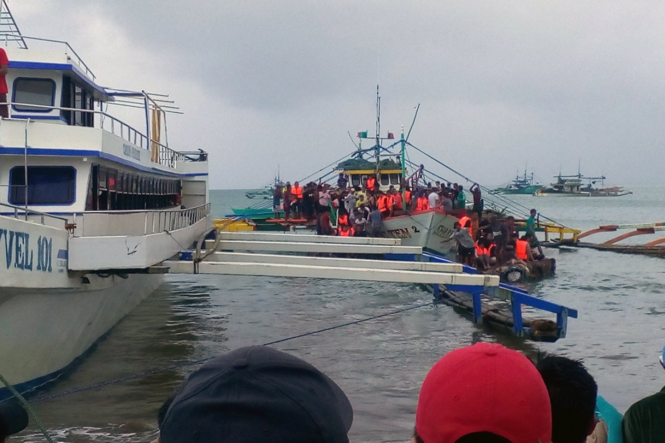 Four people are reportedly dead and 240 have been rescued after a Philippines' passenger ferry capsized in bad weather.