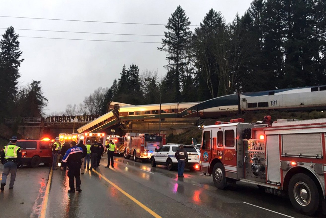 One carriage was left dangling from the bridge as another tumbled onto a busy highway.