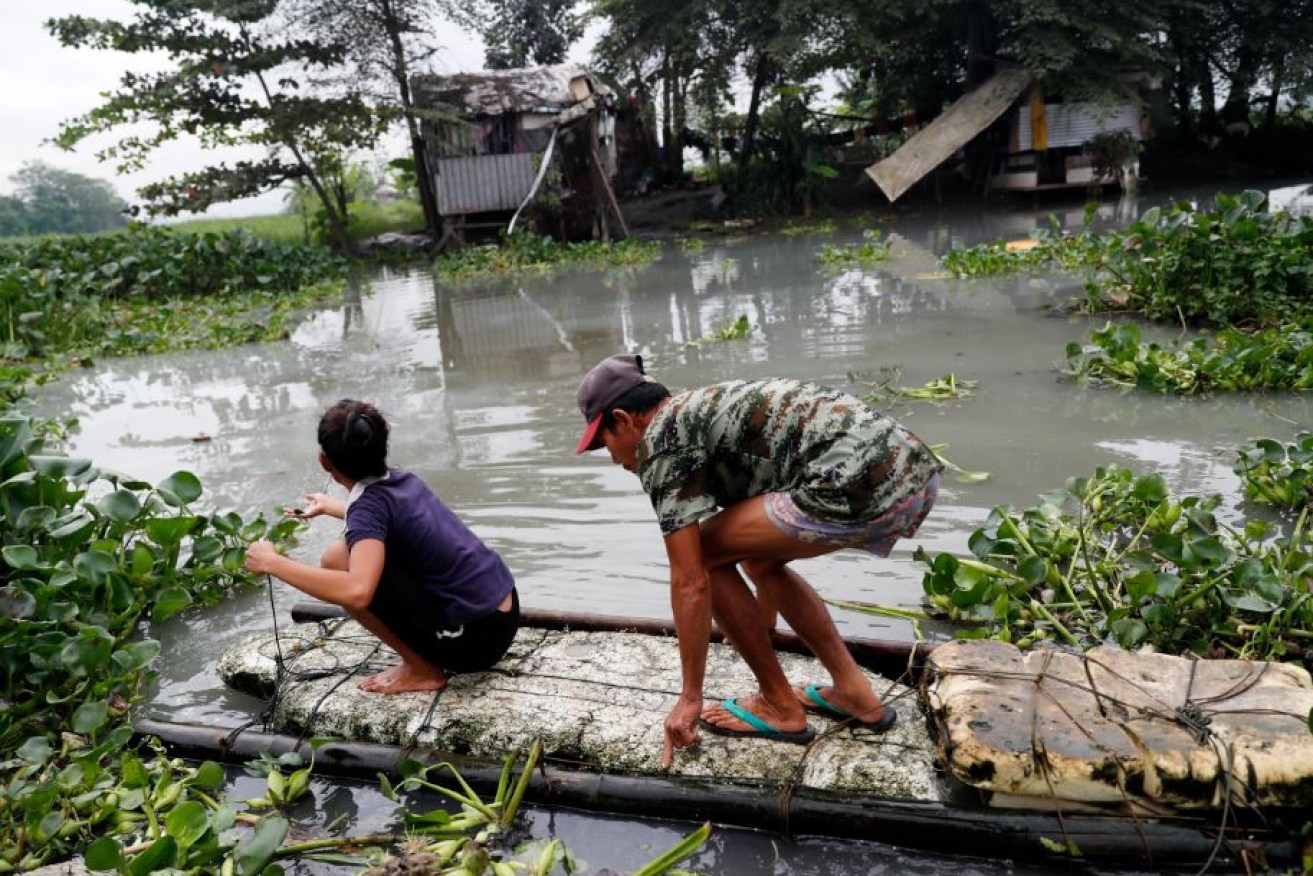 A makeshift raft is this couple's lifeline and sanctuary as floods rollover Mindanao in the southern Philippines.
