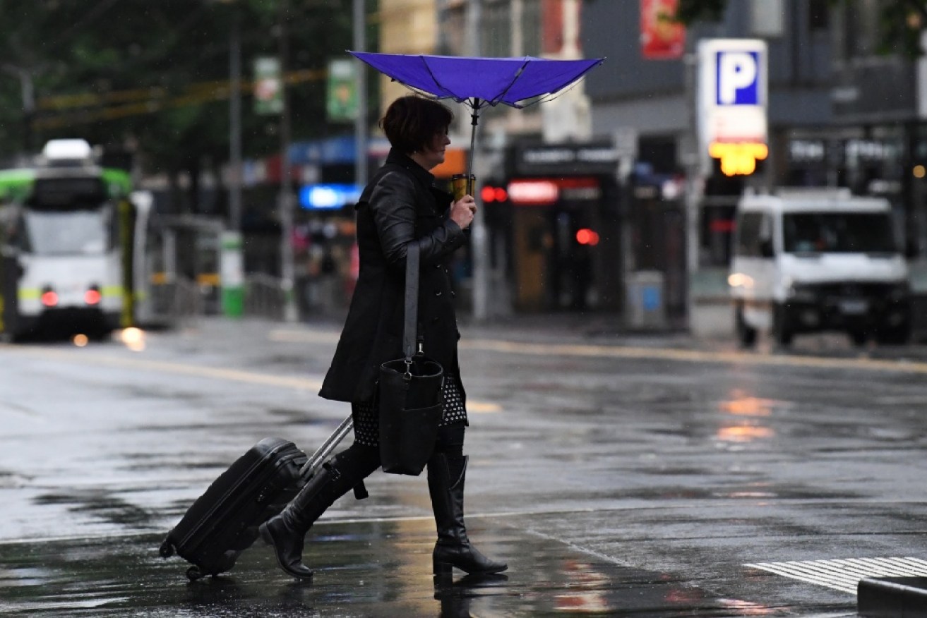 A person is seen crossing Bourke Street in Melbourne's CDB on Saturday, 