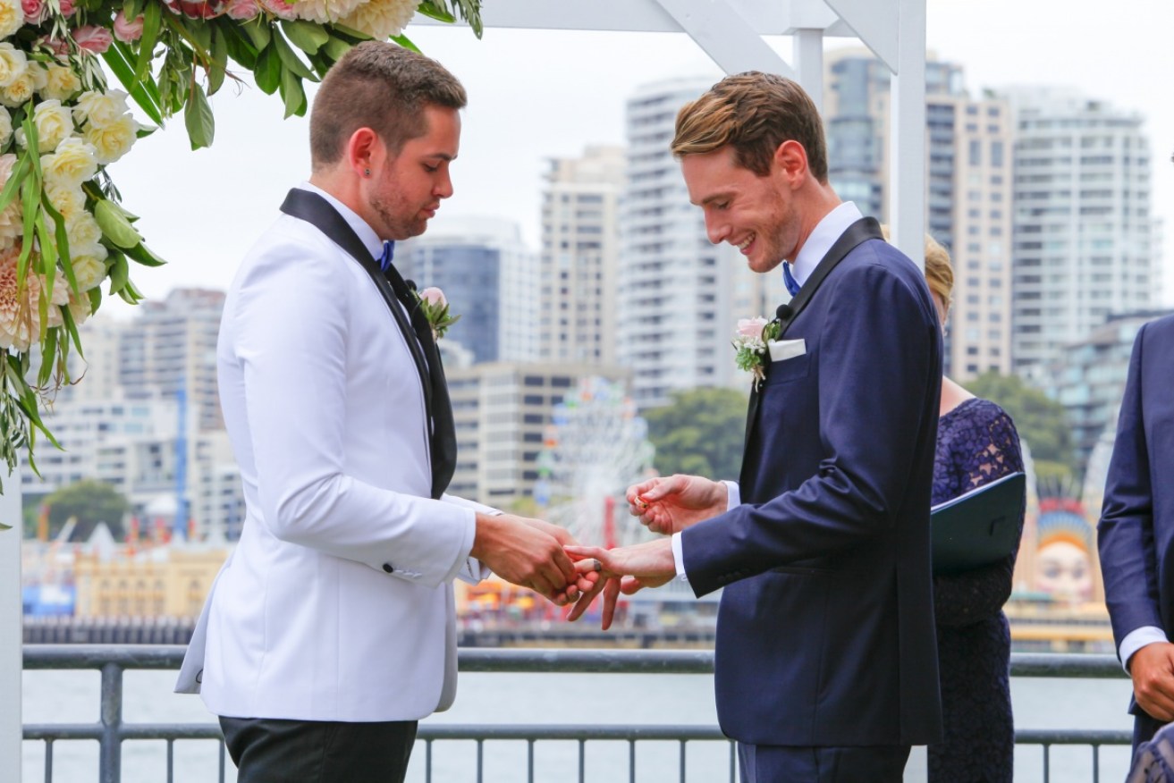 Michael Petchell and Benjamin Gresham exchange rings on a historic day at a historic location.