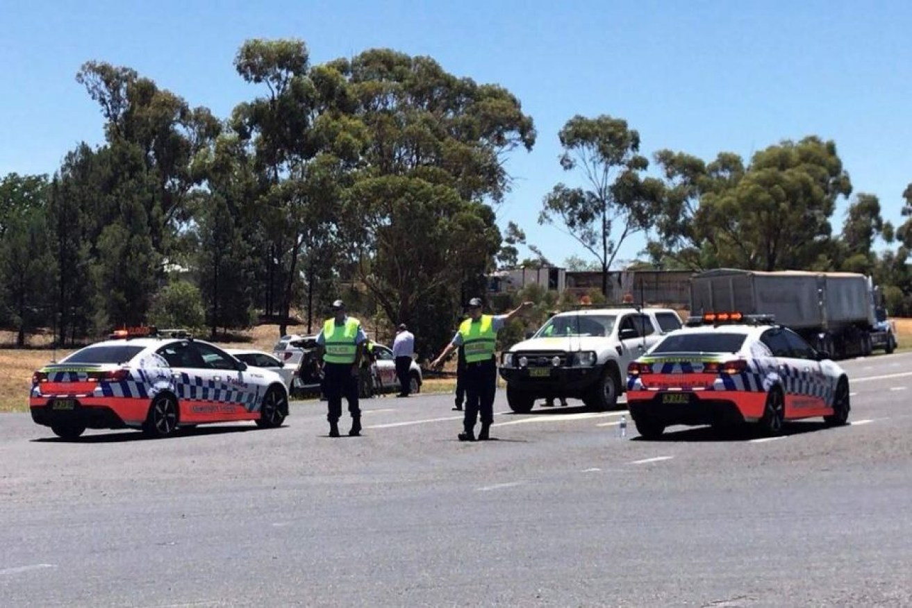 NSW Police direct traffic on the Newell Highway after a fatal crash.