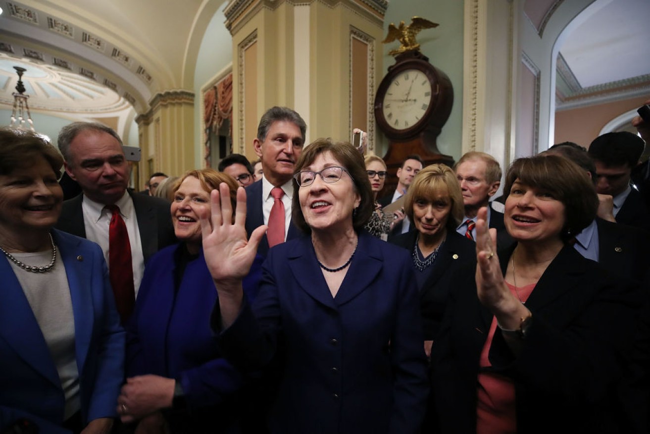 Senator Susan Collins celebrates with fellow senators after the Senate voted to reopen the government.