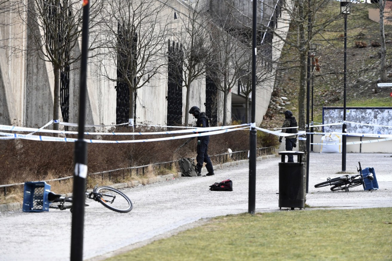 Swedish police search the area outside Varby Gard station in Stockholm.