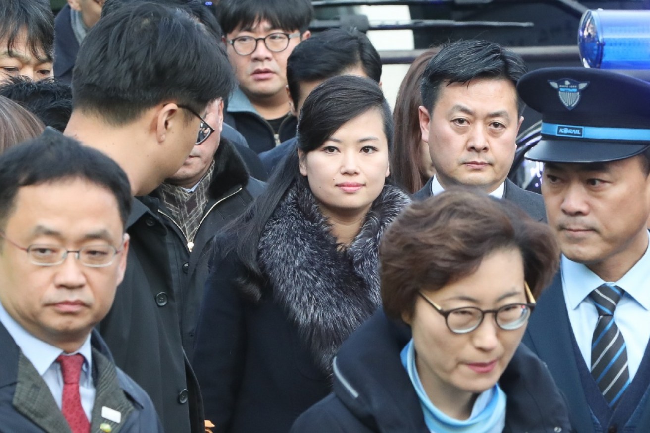 North Korean pop star Hyon Song-wol makes her way silently through a curious media pack. 