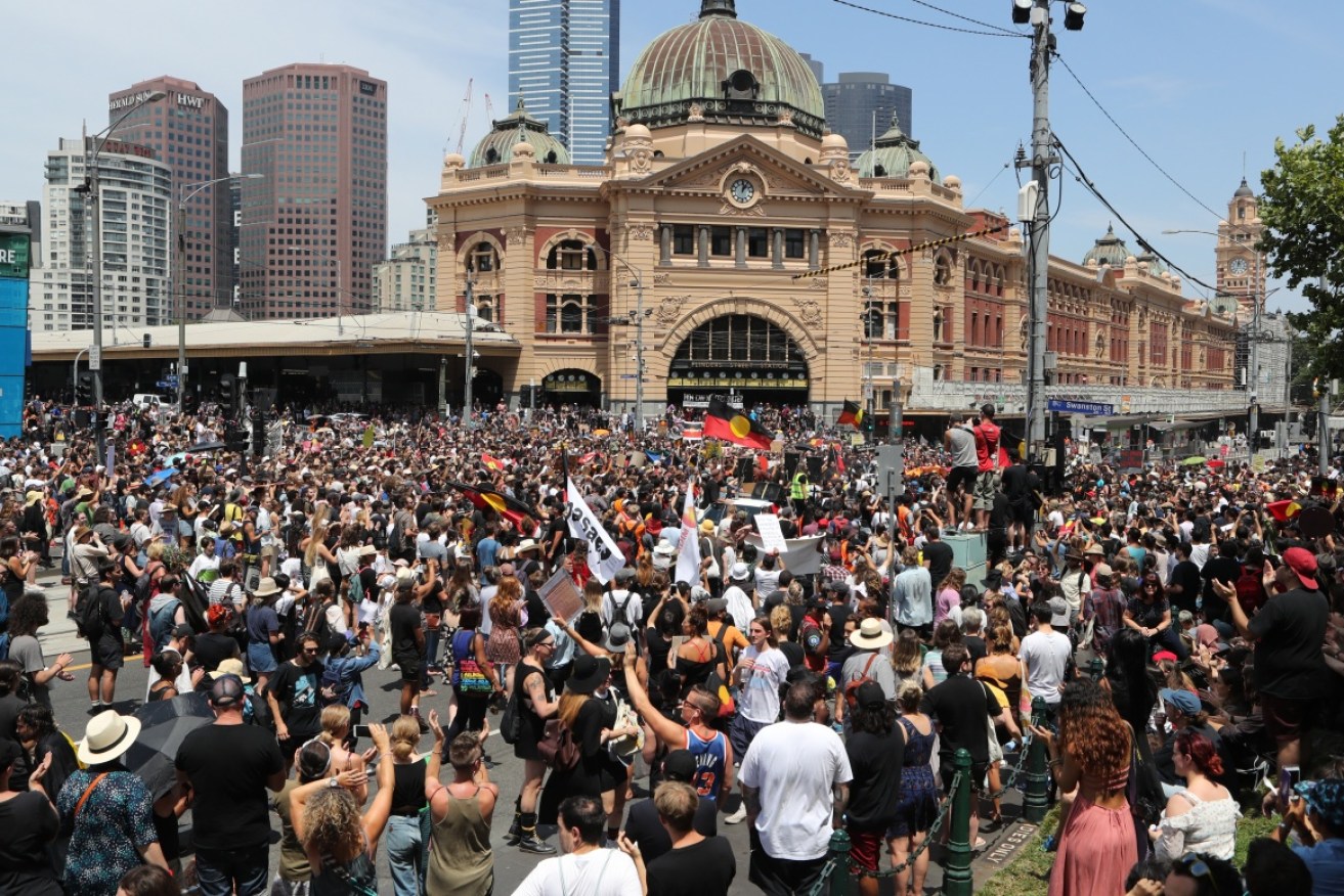 Protesters in front of Flinders Street Station in Melbourne as part of an 'Invasion Day' rally. 