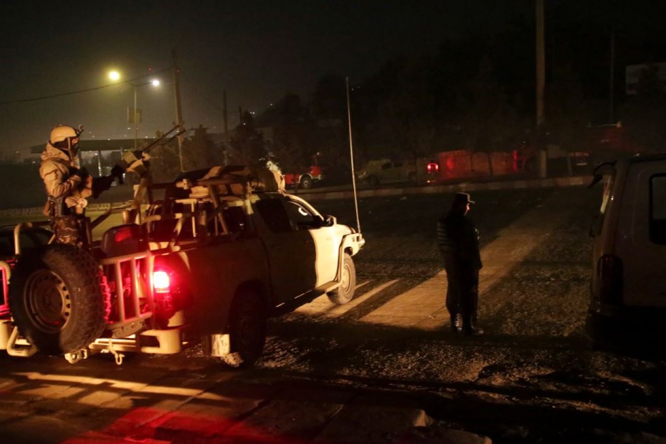An Afghan Army unit takes up position in the pre-dawn gloom outside the besieged hotel.