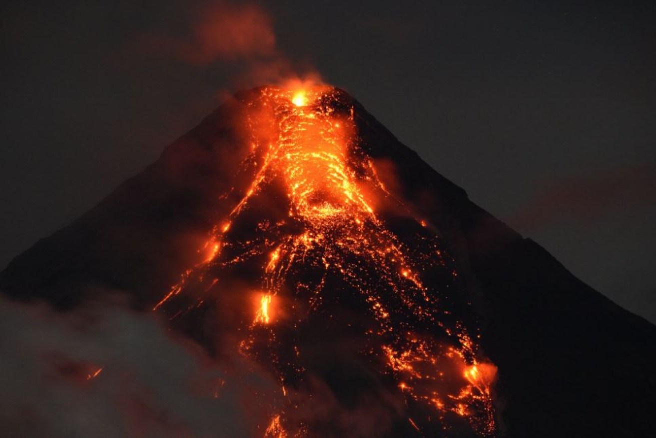 Like a vision of hell on earth, cascades of lava pour down Mount Mayon's nighttime slopes.