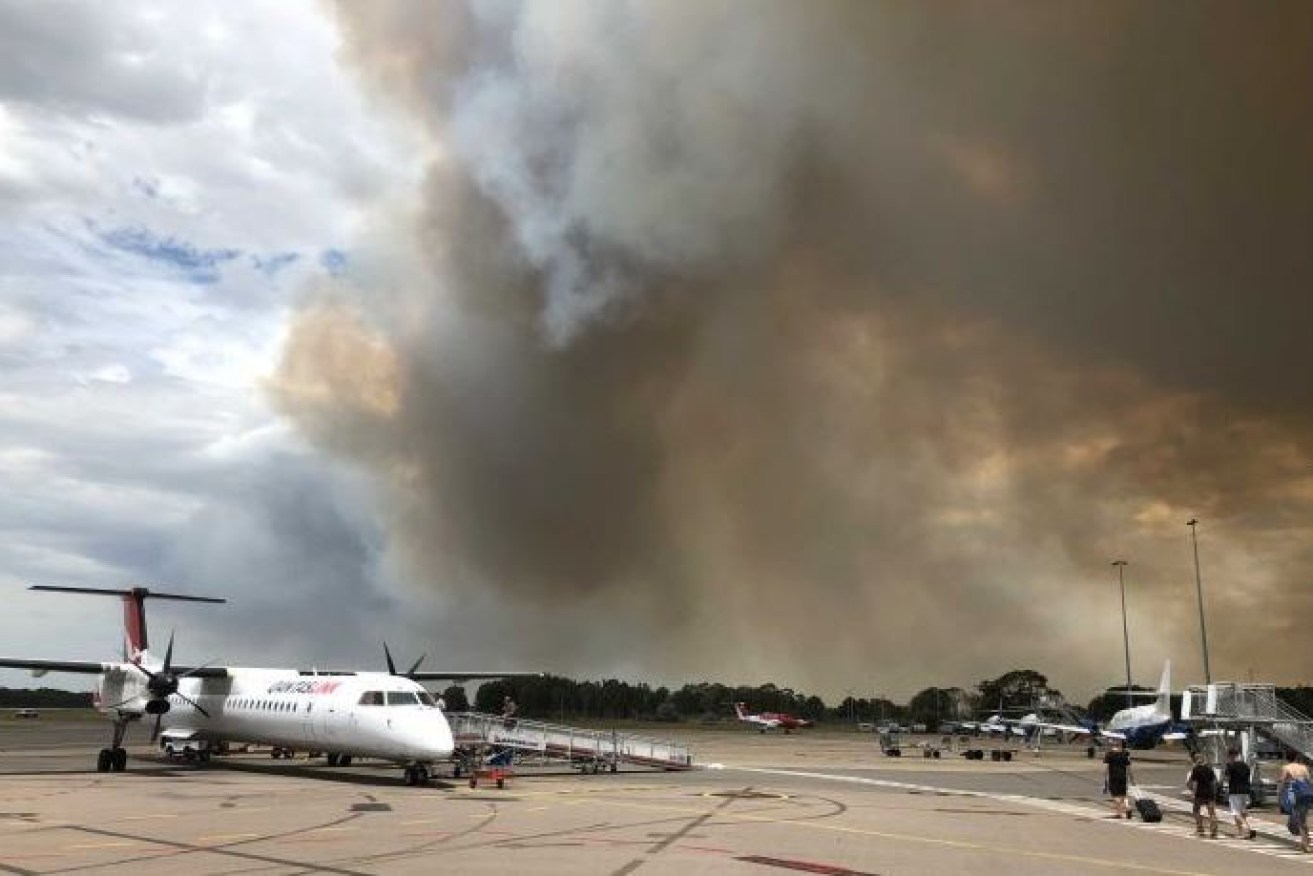 A pillar of thick smoke marks the fire's progress toward Newcastle's airport.