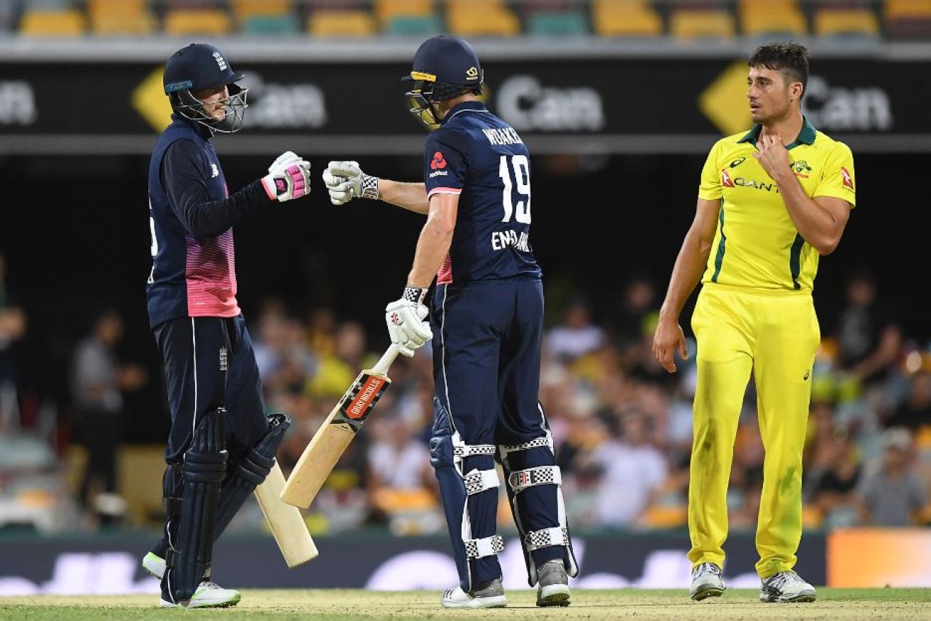 Australia's Marcus Stoinis looks stunned as England's Joe Root (left) and Chris Woakes celebrate England's latest win.