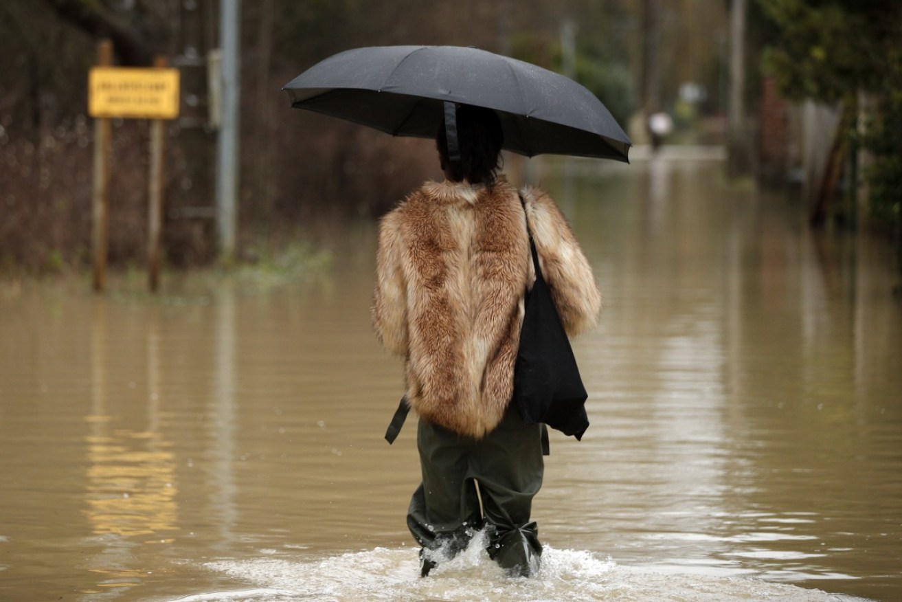 A woman walks in the middle of a flooded street by the waters of the Grand Morin in Esbly, east of Paris.