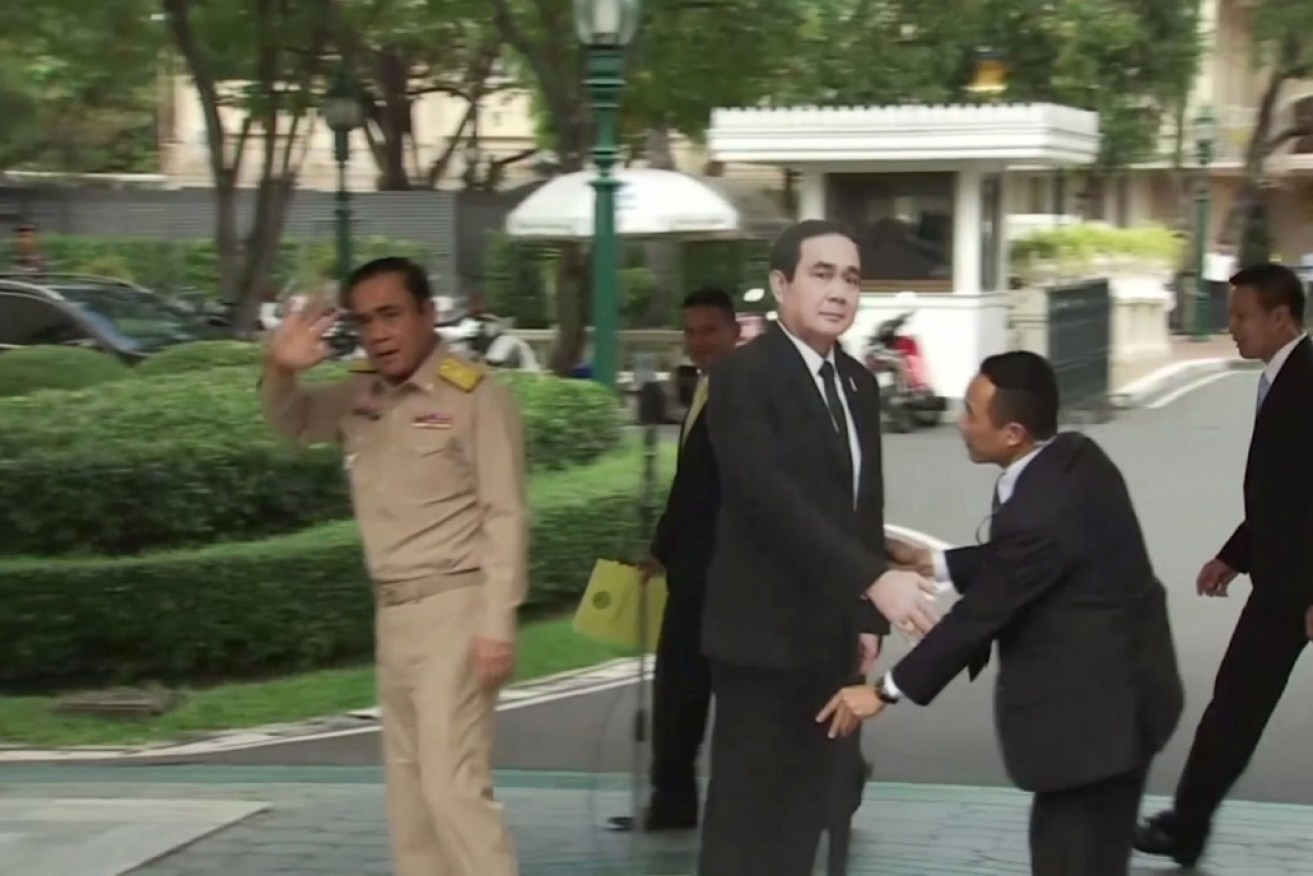 Prime Minister Prayuth Chan-ocha (left) walks out of a press conference, leaving his cardboard likeness behind.
