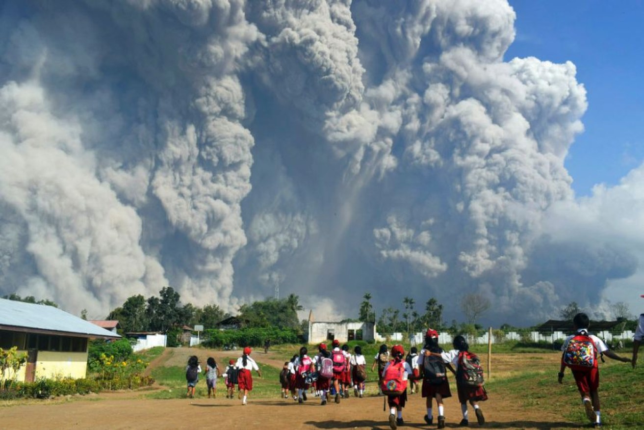 School children walk as Mount Sinabung erupts in Indonesia.