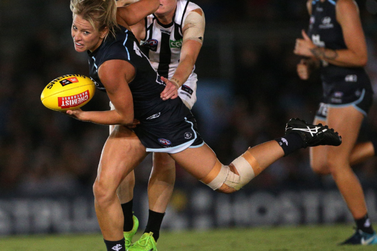 Katie Loynes of Carlton (left) is tackled by the Pies' Stacey Livingstone in the AFLW Round 1 match between the Carlton Blues.