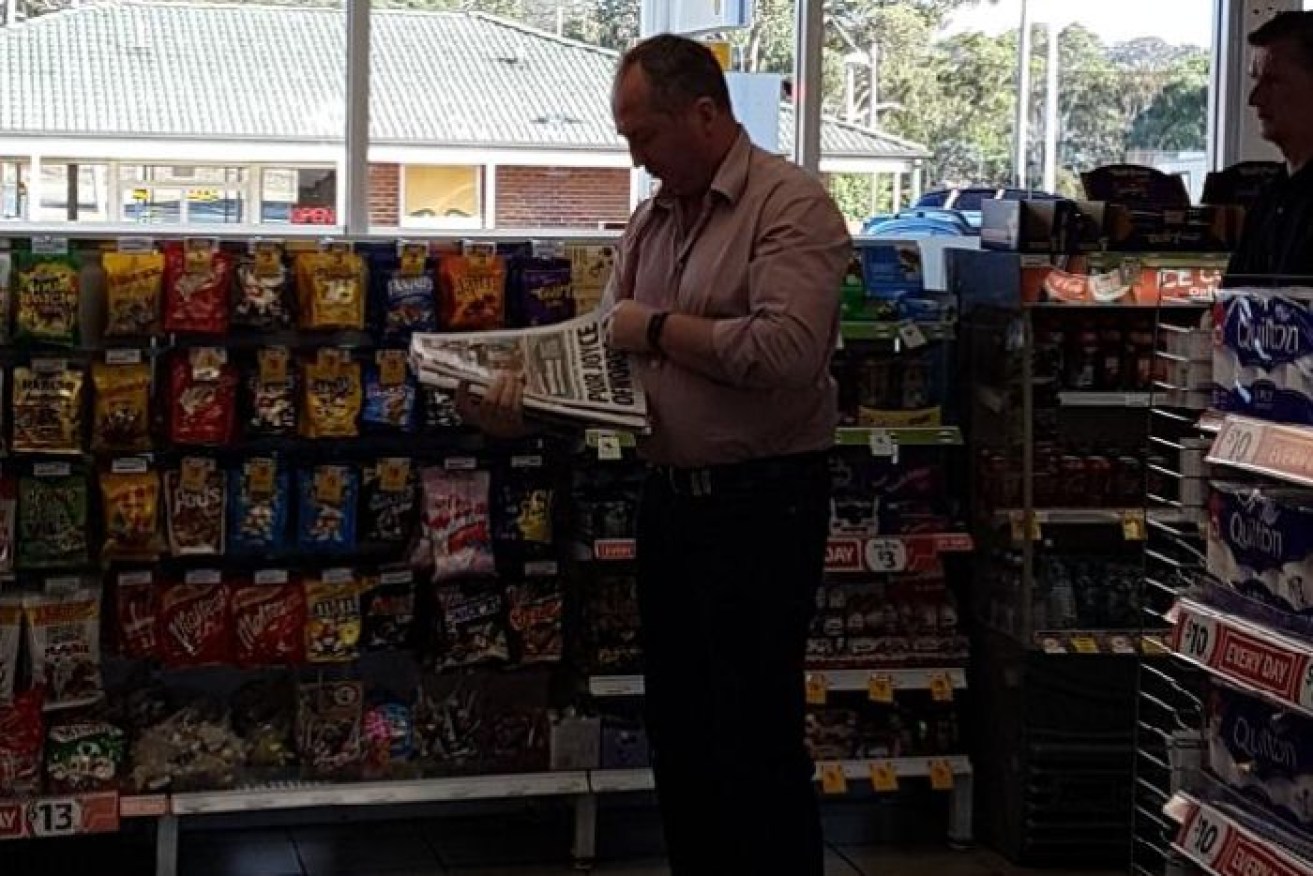 Deputy Prime Minister Barnaby reads his headlines at a petrol station while en route to Sydney and his meeting with the PM.