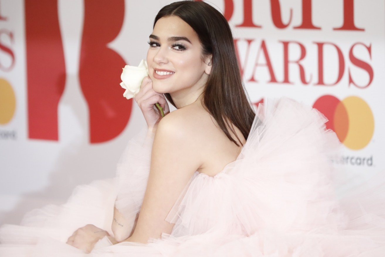 Dua Lipa, who won the Best British Female award, clutches a white rose in solidarity with sexual abuse victims.