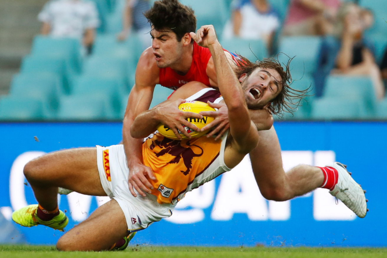 George Hewett (right) of the Swans brings down the Lions' Rhys Mathieson during the AFLX grand final . 