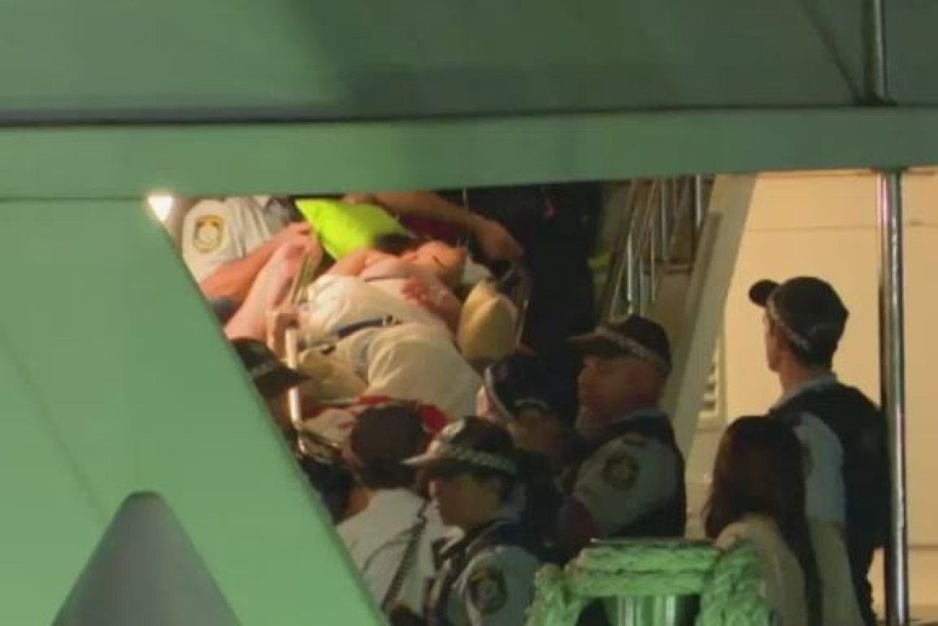 Strapped to a stretcher, an injured woman is removed from the party boat after the wild brawl.