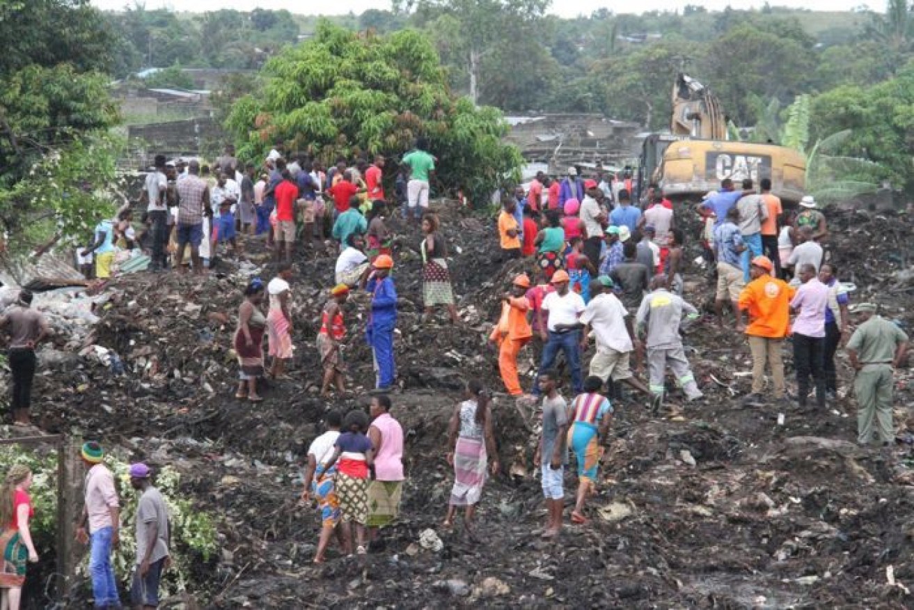 Locals picks through the garbage mound that killed 17 in Mozambique.