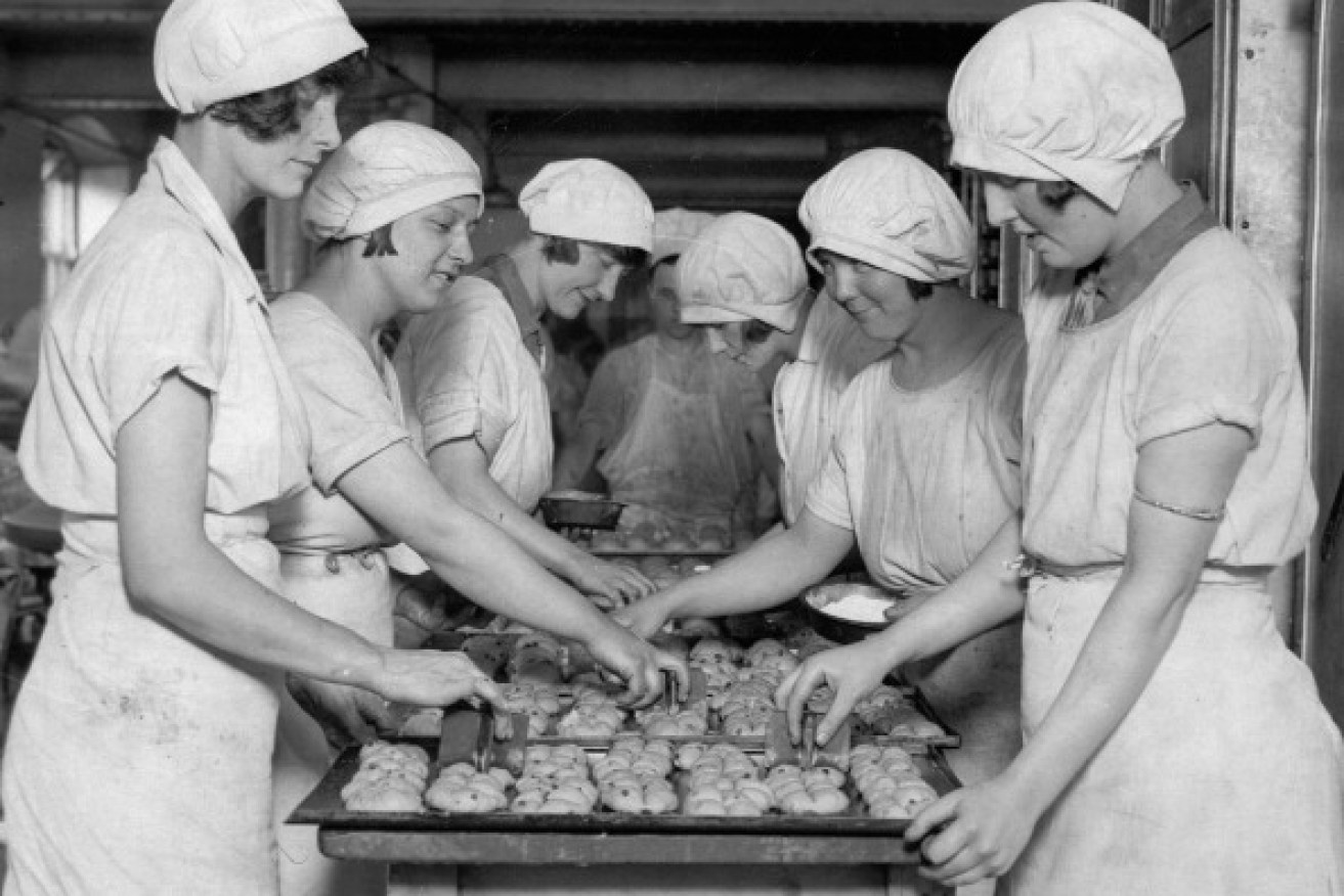 Young girls at a London bakery, stamping crosses on the hot cross buns for Easter in 1930. 