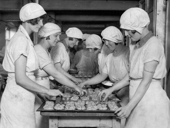 Young girls at a London bakery, stamping crosses on the hot cross buns for Easter in 1930.